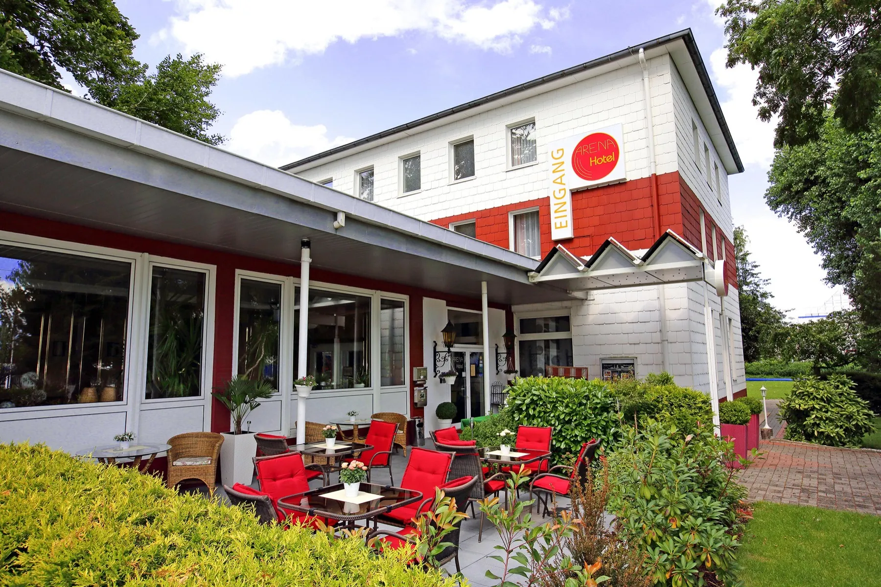 Außenansicht des Arena Hotels bei Tag mit Terrasse