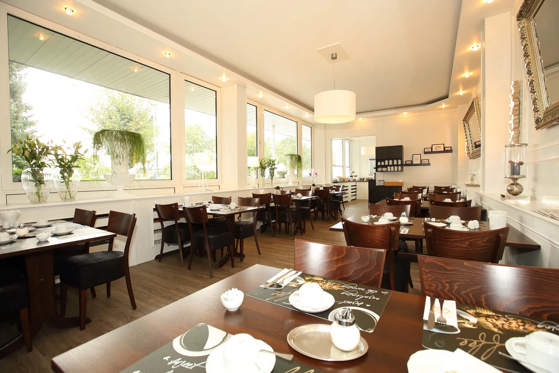 Heller Frühstücksraum mit großen Fenstern im Arena Hotel