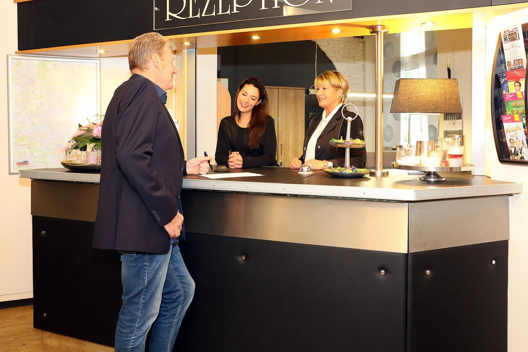 Ein Gast wird an der Rezeption des Arena Hotels begrüßt