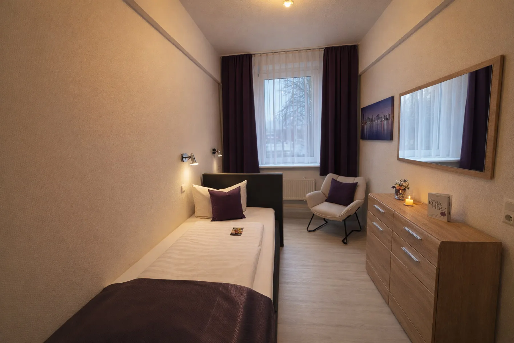 Einzelzimmer Standard mit Bett, Sessel und Kommode im Arena Hotel