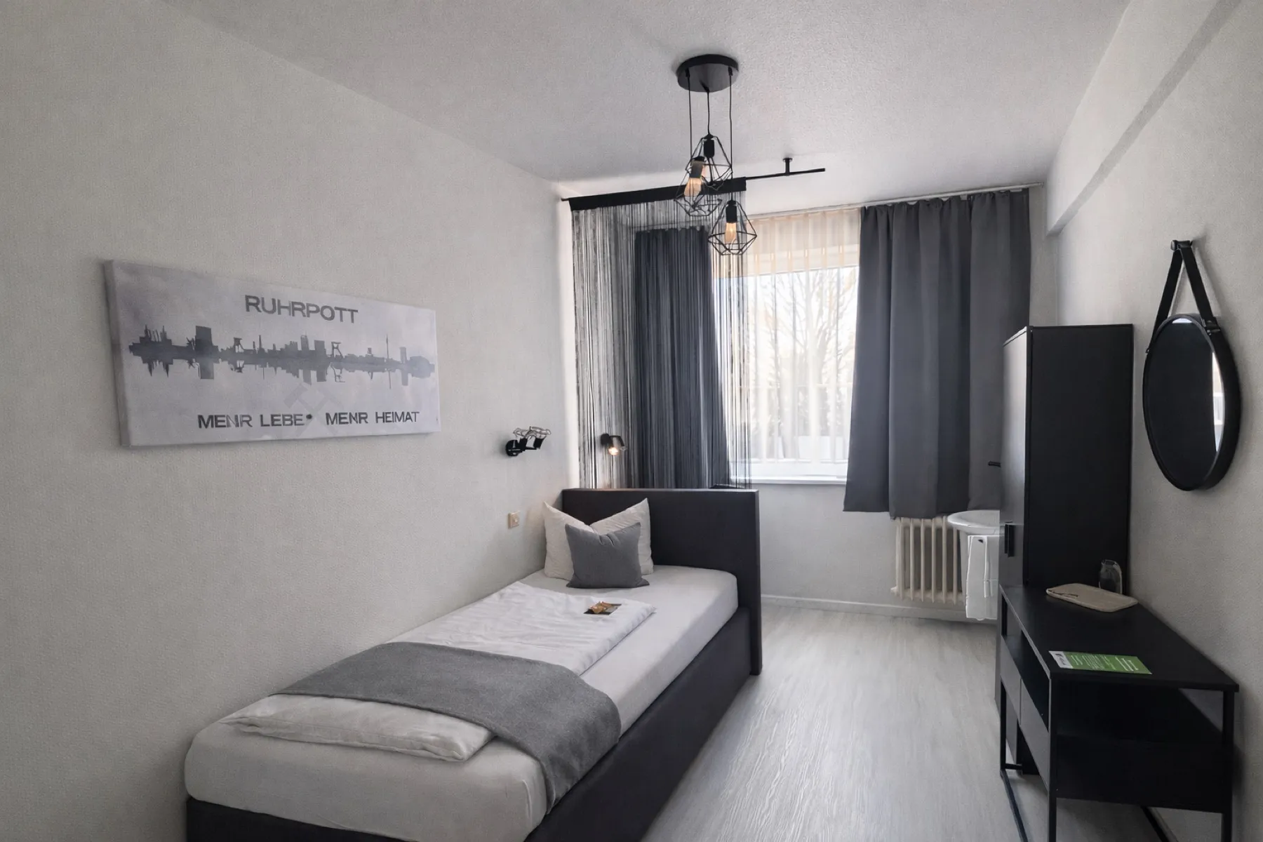 Einzelzimmer mit Waschgelegenheit, Bett und Schreibtisch im Arena Hotel